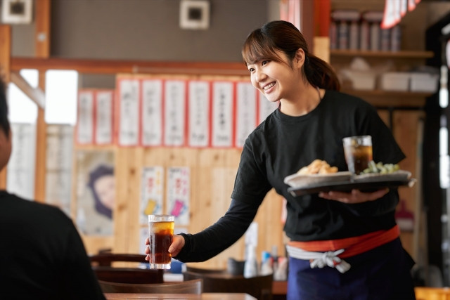 waitress serving drinks at an izakaya